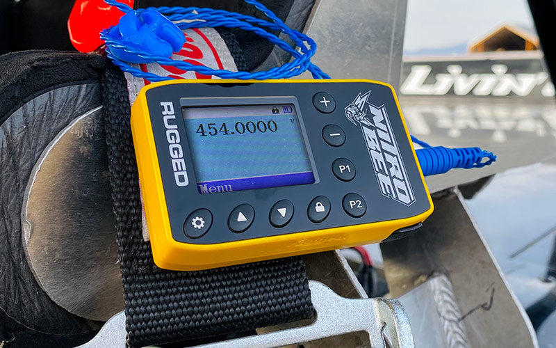 A yellow and black Nitro Bee Xtreme is fastened to a black strap on vehicle headrest.